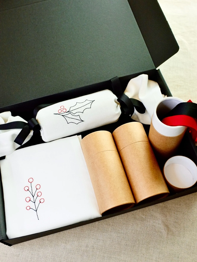 Gift box containing fabric Christmas cracker set, including cardboard gift tubes, and red and black ribbons