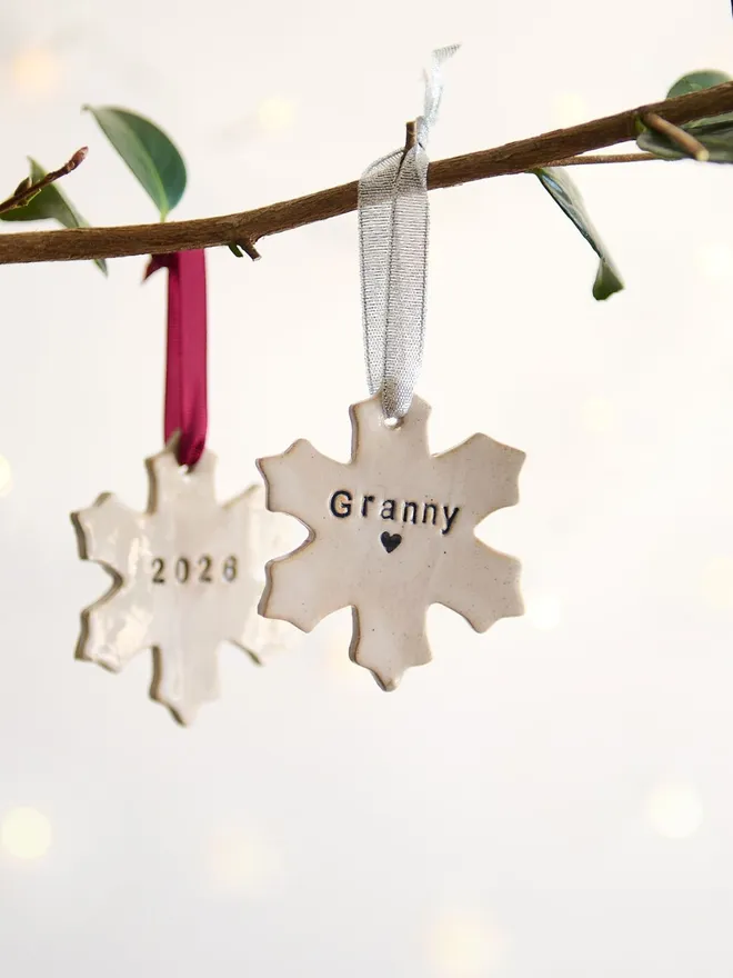 hanging personalised snowflake decorations on a branch