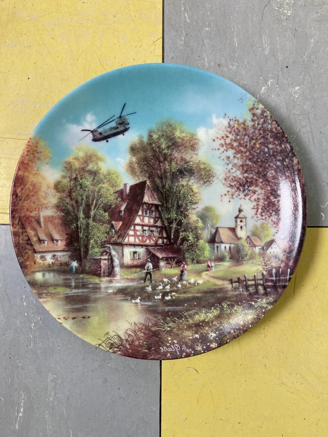 Vintage plate featuring a rural scene with a Chinook Helicopter flying overhead.