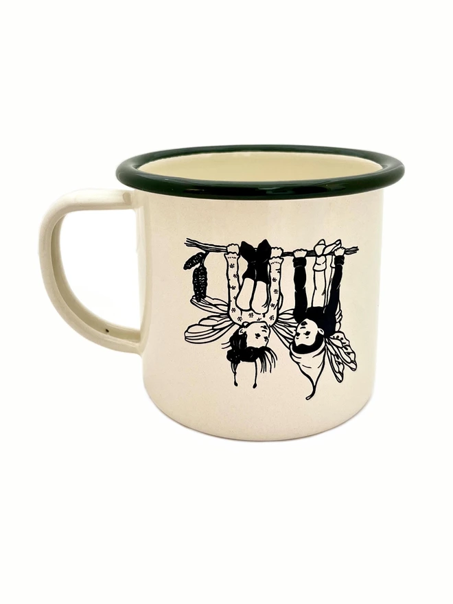 a vintage style enamel mug cream in colour with a bottle green rim etched with 2 cheeky pixie pals swinging upside down on a twig