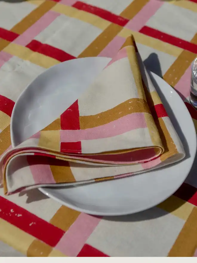 Folded napkin on plate on tablecloth