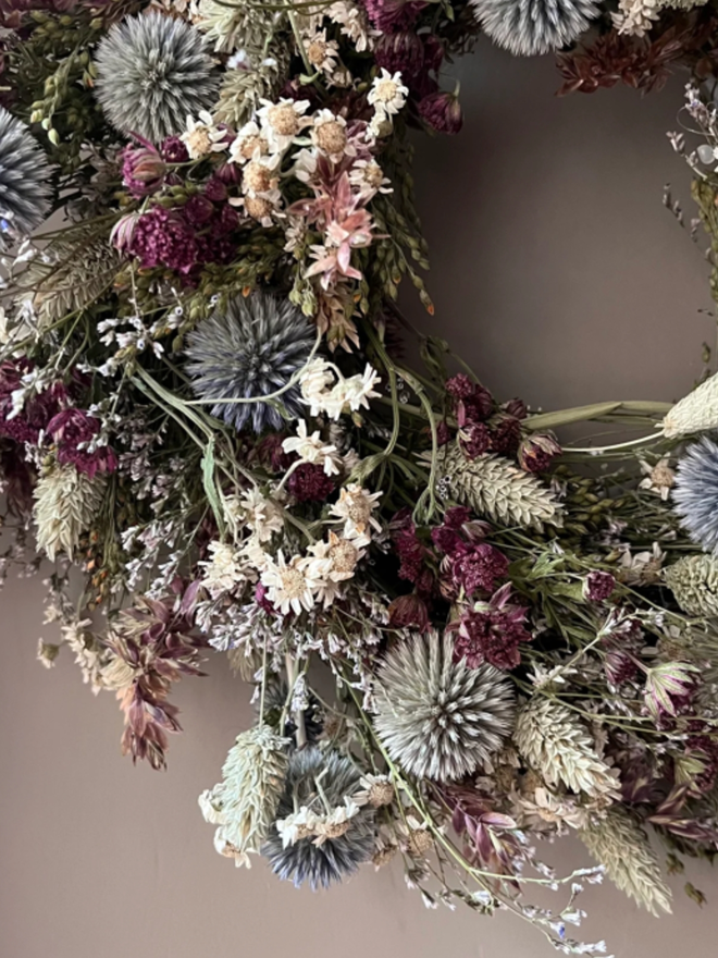 Winter Flowers Wreath. A wreath made of winter flowers and hung on a wall.