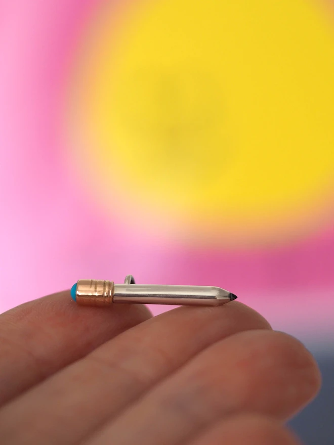 Turquoise dinky pencil charm on a hand