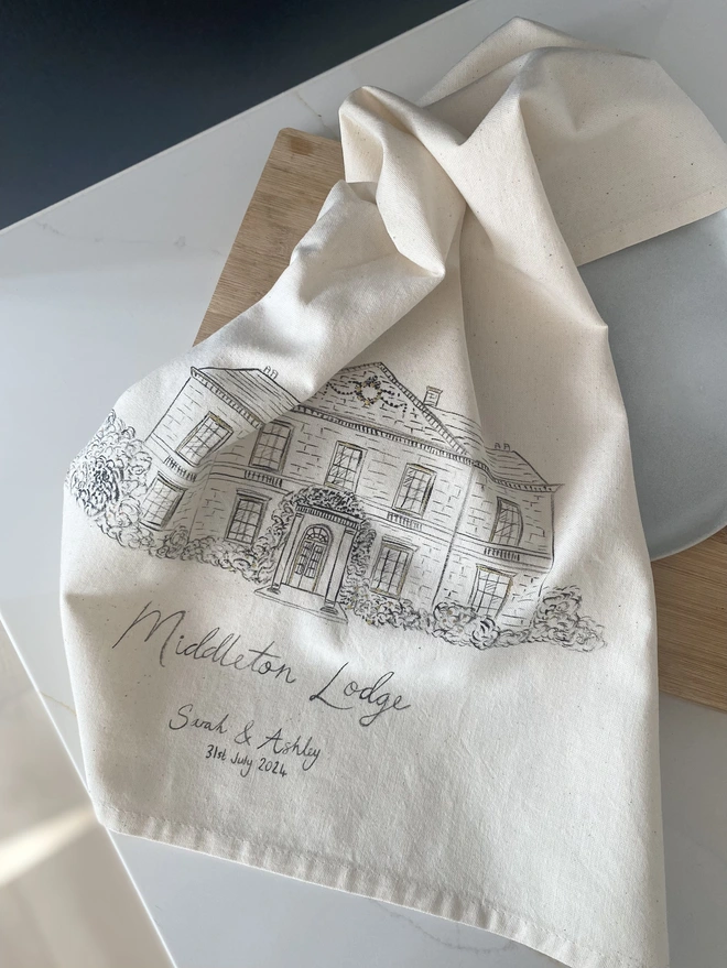 Tea towel with a hand painted venue illustration 