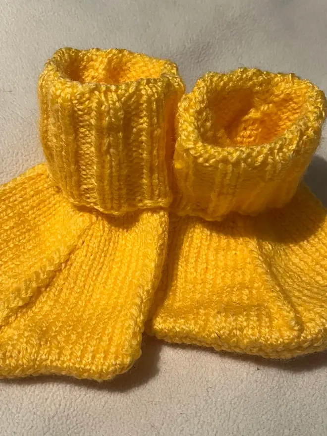 Duck Feet Socks, a pair of yellow duck feet socks sitting on a plain surface. 