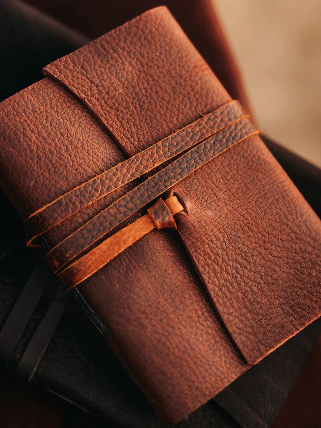 reclaimed saddlery leather journal. a brown leather journal in foreground.