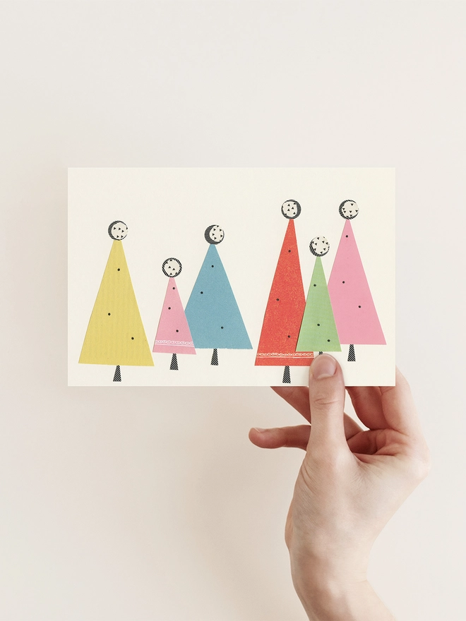 A Christmas card featuring a forest of abstract trees in pastel colours.