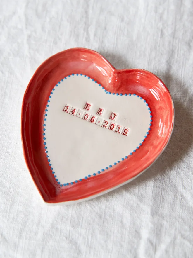 Personalised ceramic heart trinket dish, placed on a plain white table cloth 
