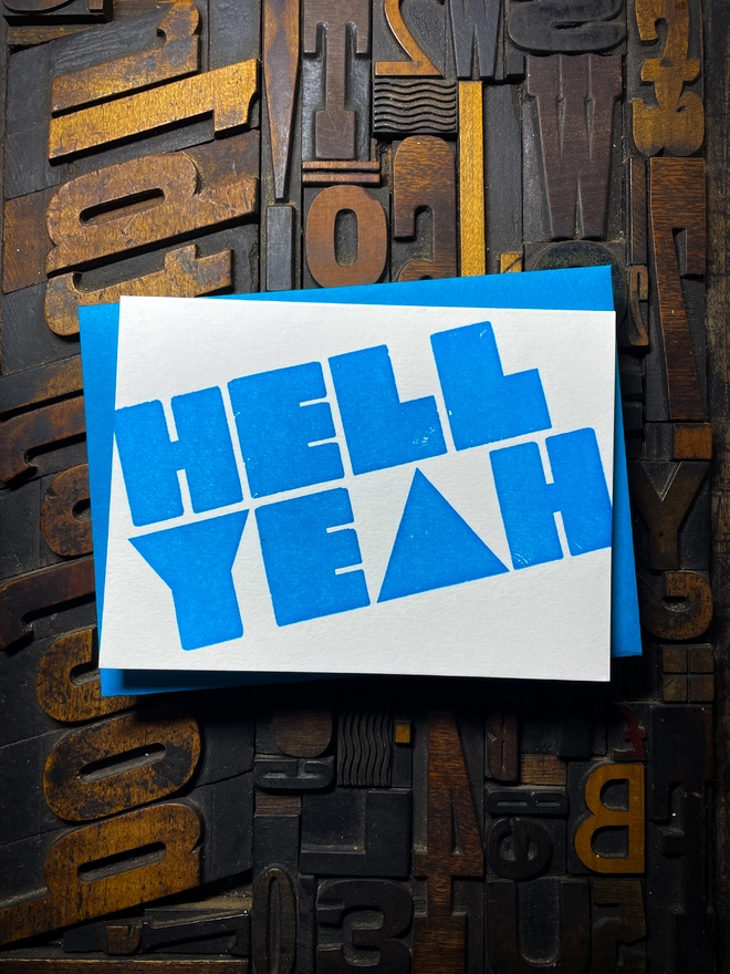 A congratulatory letterpress card using vibrant fluorescent inks the deep impression word HELL YEAH; in bold letters with a set of colourful envelopes. Perfect for exam results and graduations and other celebrations and milestones.