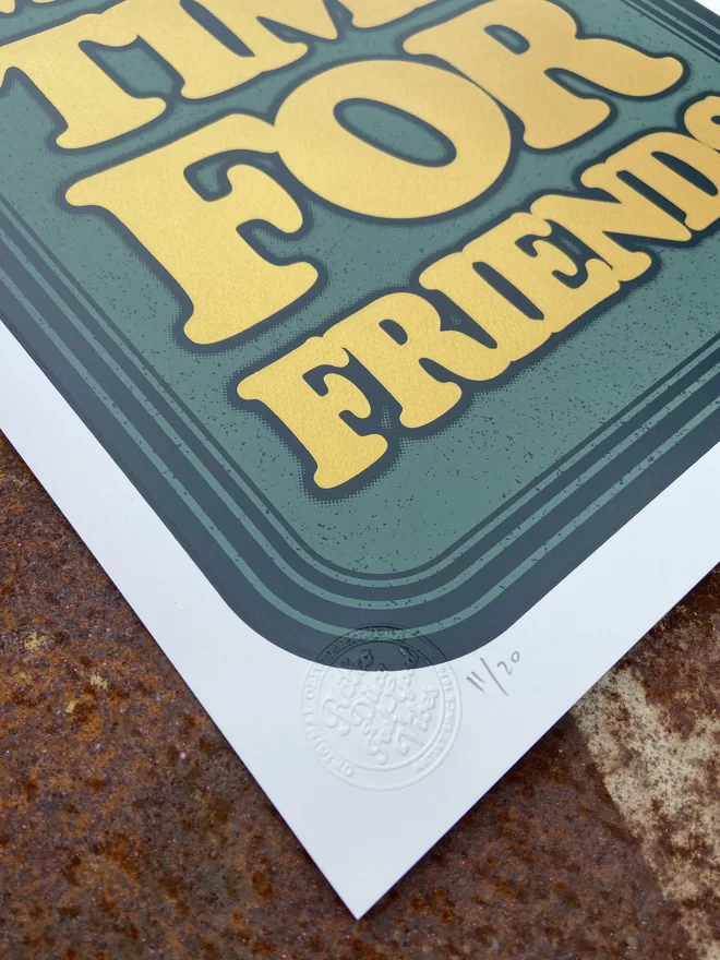 green leather looking screen print with gold letters that says “make more time for friends”