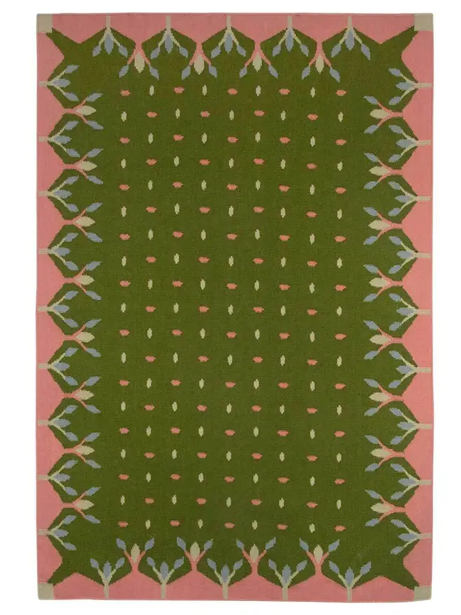 Hedgerow Flatweave Rug, a colourful rug sitting on a plain backdrop. 