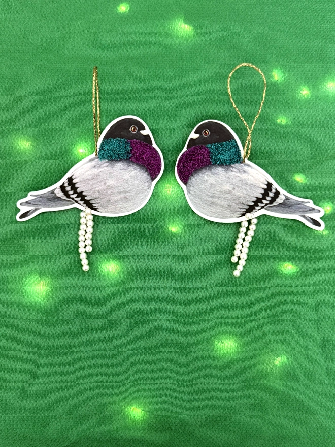 Pooping pigeon decorations with faux pearls and eco glitter on a green background with Christmas lights 