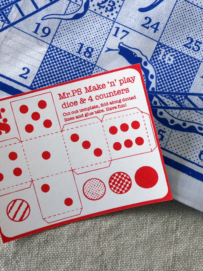 detail of a Mr.PS Snakes & Ladders hankie in blue with a red printed make'n'play card