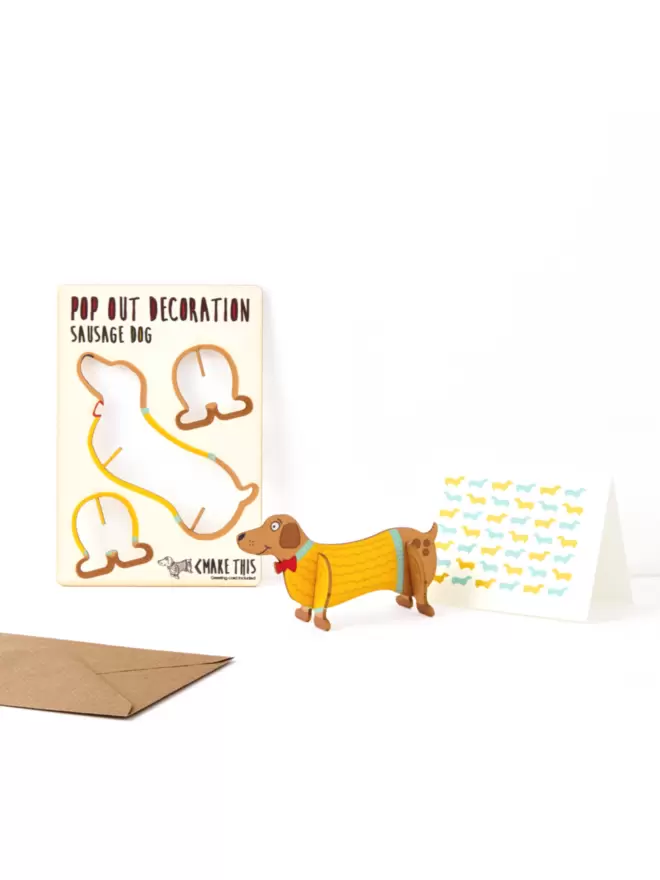 Sausage dog decoration with sausage dog greeting card and brown kraft envelope on a white background