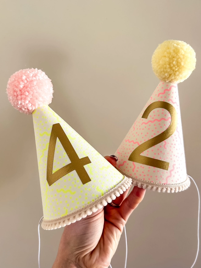 Pink and Yellow party hats with matching pom poms