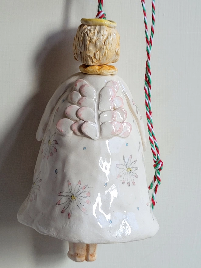 back view of and angel bell with daisies and halo and twine to hang up