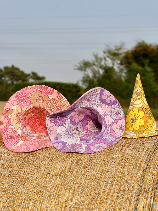 Three halloween witch style hats on a bail of straw ready for Samhain