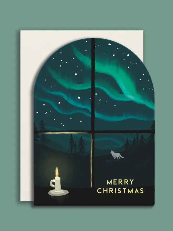 Arched shape Christmas card with white envelope, with an illustrated window snowing the northern lights and a white fox.