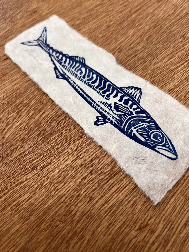 Hand-printed mackerel lino print on natural handmade paper, featuring a bold graphic illustration of a mackerel.