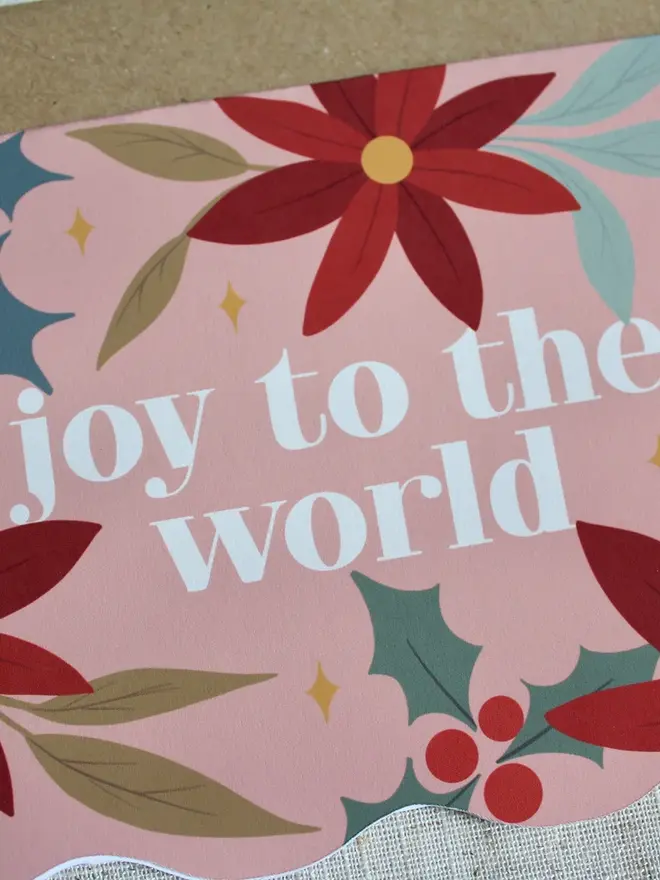 joy to the world floral christmas card. wavy edged pink floral card emblazoned with joy to the world.