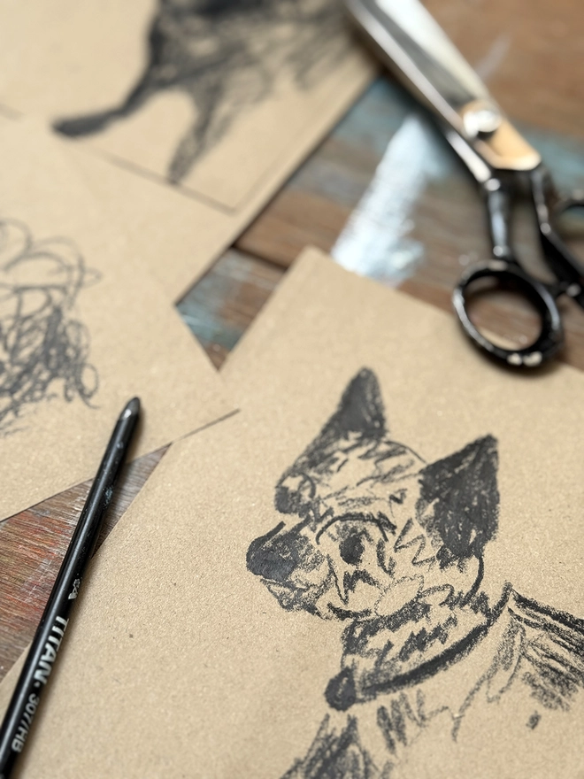 drawings of dogs on brown paper on a drawing board